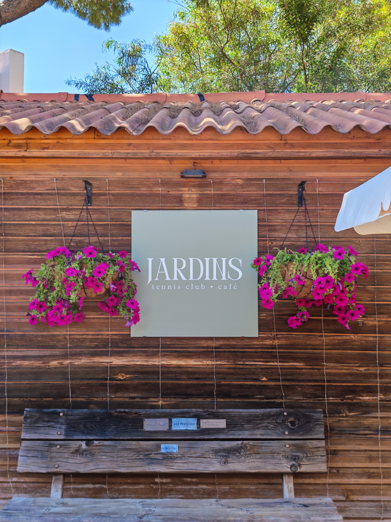 Jardins tennis club and café sign with hanging flowers